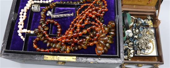 A brown leather box of Victorian and later costume jewellery including a selection of tiepins